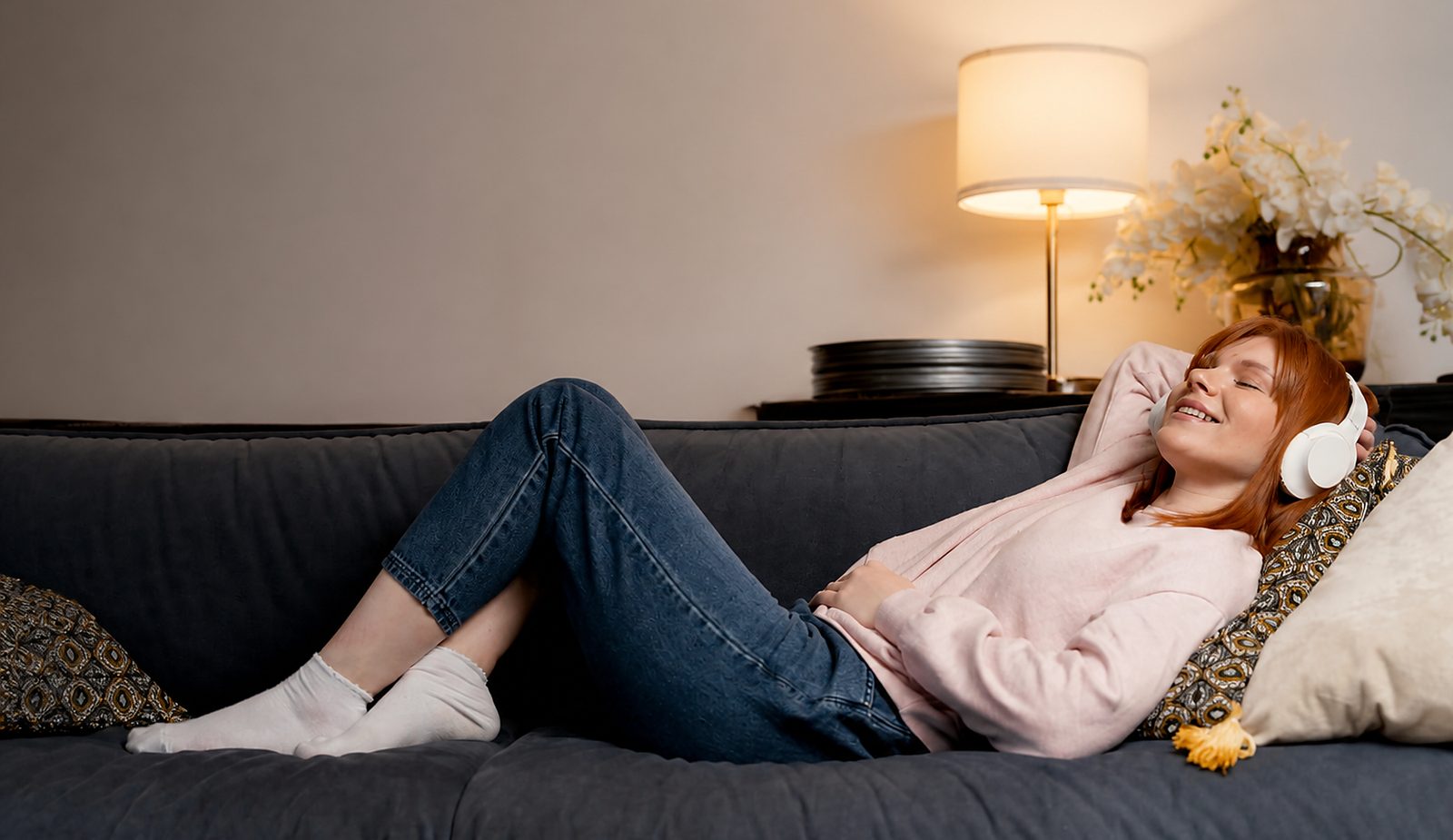 Creator relaxing on a sofa with headphones while automations run
